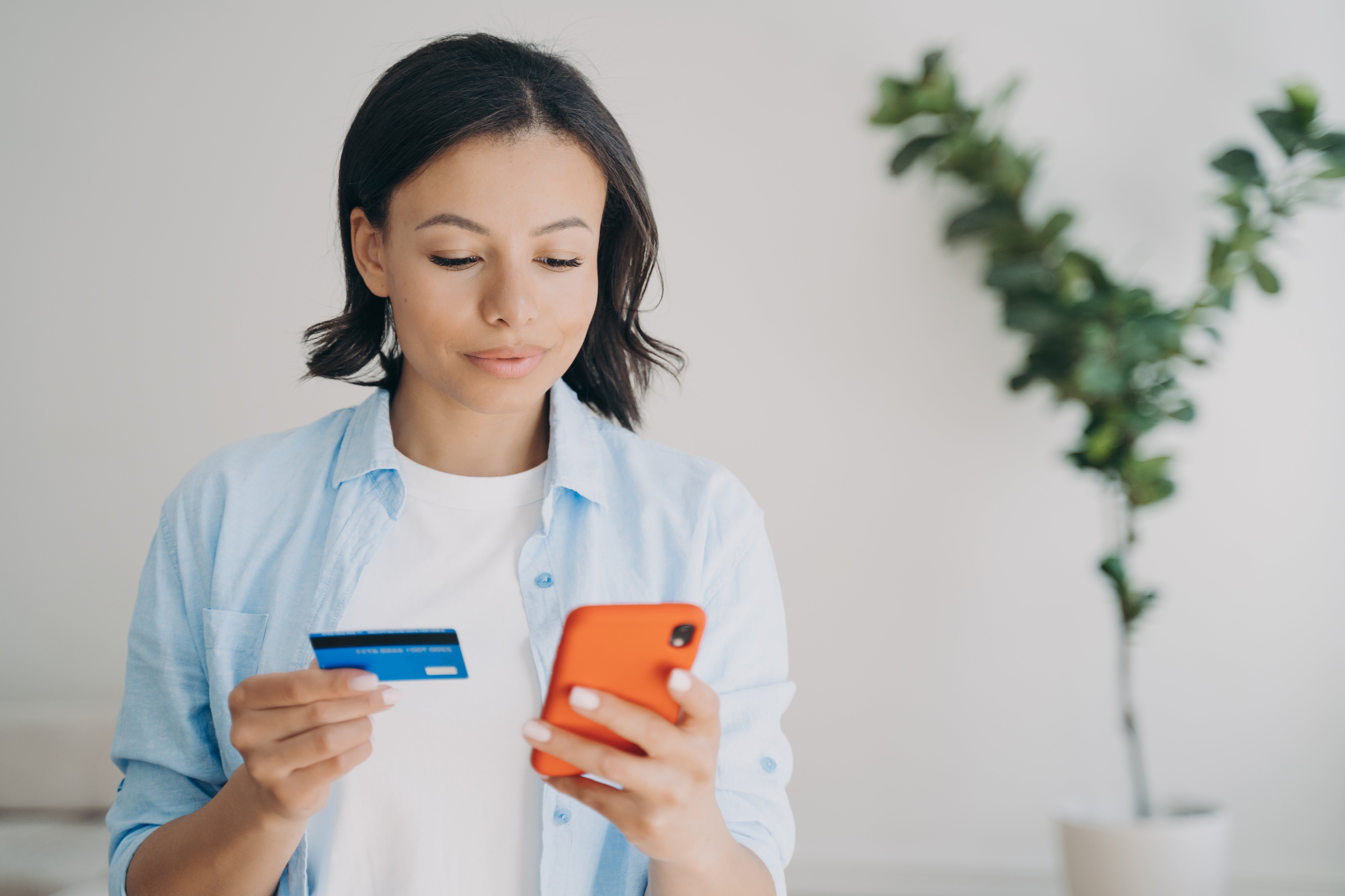 female-holding-bank-credit-card-smartphone-using-2022-08-23-16-48-08-utc